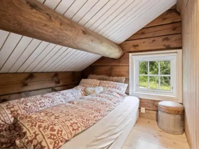 a bedroom with a bed and a window at Timber Cabin With Soul At Kvamskogen in Norheimsund