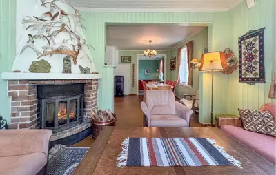 a living room with a fireplace and a couch at 7 Bedroom Lovely Home In Tufsingdalen in Bakken