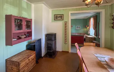 a dining room with a table and a wood stove at 7 Bedroom Lovely Home In Tufsingdalen in Bakken