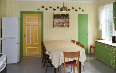 a kitchen with a table with chairs and a refrigerator at 7 Bedroom Lovely Home In Tufsingdalen in Bakken
