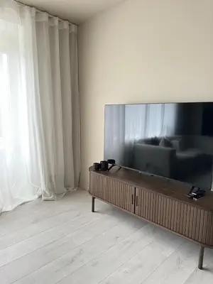 a living room with a large flat screen tv at Elegant city apartment in Bergen- Private outdoor patio and free parking in Bergen