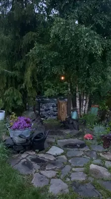 a garden with a stone pathway with flowers and trees at Idyllic house in Hurdal 2 bedroom in Hurdal