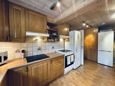 a kitchen with wooden cabinets and a white refrigerator at Red Cross Cabin, Spacious mountain lodge in Gol