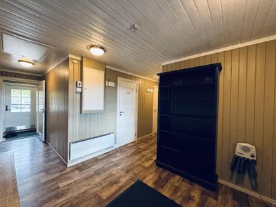 a room with wood floors and a black closet at Red Cross Cabin, Spacious mountain lodge in Gol