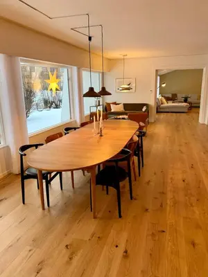 a dining room with a large wooden table and chairs at Large Architect Designed Home in City Centre in Hamar