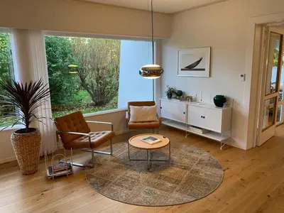 a living room with chairs and a table and a window at Large Architect Designed Home in City Centre in Hamar