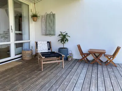 a porch with two chairs and a bench and a table at Large Architect Designed Home in City Centre in Hamar