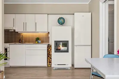 a kitchen with white cabinets and a refrigerator at Eden Oasis, Bakklandet with Free parking! in Trondheim