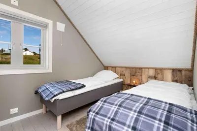 a attic bedroom with two beds and a window at Raffelbrygga in Bud