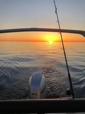 a boat with a fishing rod in the water at Raffelbrygga in Bud