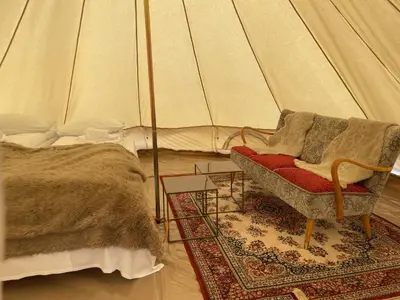 a room with a bed and a chair in a tent at Syndinstøga in Ryfoss
