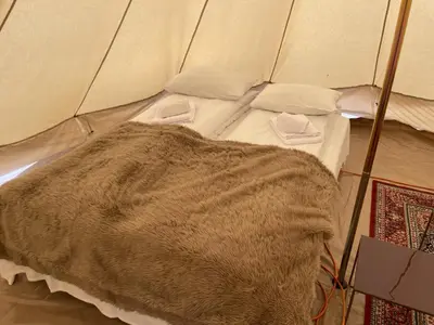 a bed in a tent with a blanket on it at Syndinstøga in Ryfoss