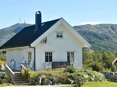 a white house with mountains in the background at 5 person holiday home in Oksvoll in Oksvoll