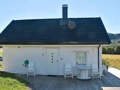 a white building with chairs and a table on a deck at 5 person holiday home in Oksvoll in Oksvoll