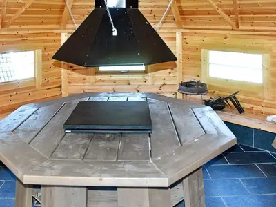 a large wooden table in a cabin with a light at 5 person holiday home in Oksvoll in Oksvoll