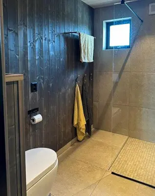 a bathroom with a toilet and a shower at Modern Cabin With Archipelago Views in Bremnes