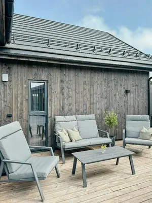 a patio with two chairs and a table and a couch at Modern Cabin With Archipelago Views in Bremnes