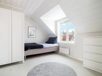 a small bedroom with a bed and a window at Sentralt beliggende enebolig på Møllenberg in Trondheim
