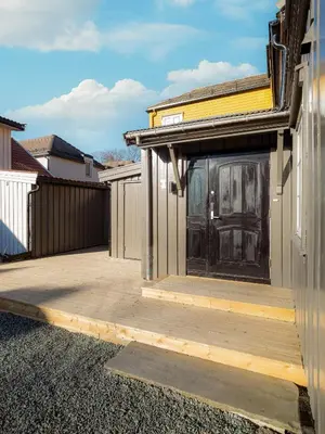 a patio with a black door on a house at Sentralt beliggende enebolig på Møllenberg in Trondheim