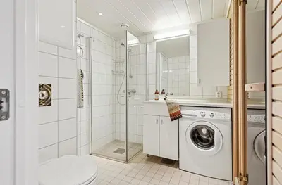 a bathroom with a washing machine and a shower at Pellestova - Hafjell in Øyer