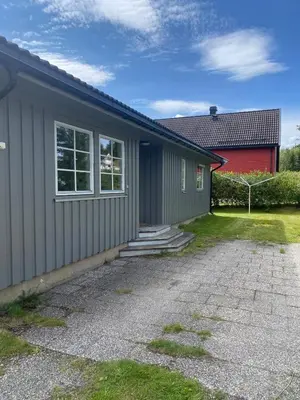 a house with a red building and a driveway at Cozy house with free parking on the premises in Ringebu
