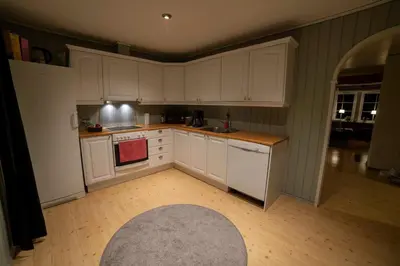 a kitchen with white cabinets and a rug at Cozy house with free parking on the premises in Ringebu