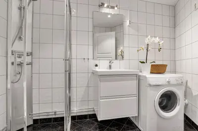 a white bathroom with a washing machine and a sink at 307SB10 - Three Bedroom Stay in Bergen