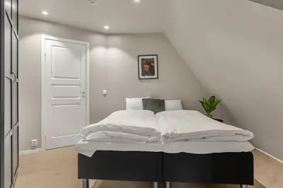 a white bedroom with a bed with white sheets at 307SB10 - Three Bedroom Stay in Bergen