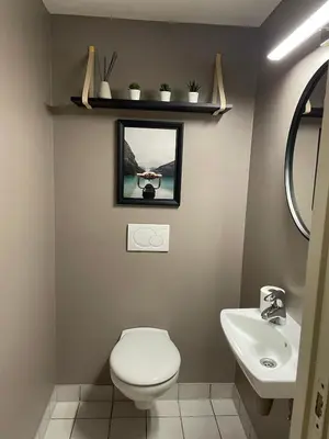a bathroom with a toilet and a sink and a mirror at Modern apartment in the middle of Bergen city center in Bergen