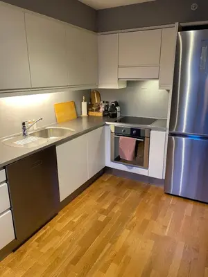 a kitchen with white cabinets and a stainless steel refrigerator at Modern apartment in the middle of Bergen city center in Bergen