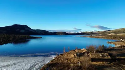 a view of a lake with mountains in the background at Flaksjøen in Venabygd