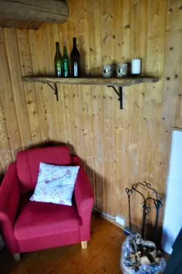 a red chair sitting in a room with wooden walls at Flaksjøen in Venabygd
