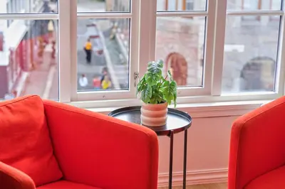 a room with two red chairs and a plant on a table at HD Central Topfloor in Bergen