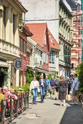 a group of people walking down a street with buildings at HD Central Topfloor in Bergen