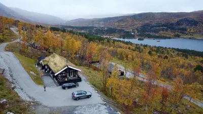 a house with a car parked in front of it at Log Cabin At The Foot Of Hallingskarvet in Hovet