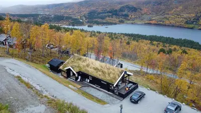 a truck with grass on the back driving down a road at Log Cabin At The Foot Of Hallingskarvet in Hovet