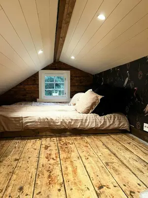 a bed in a room with a wooden floor at Restored Farmhouse By The Sea In Kvalheim in Raudeberg
