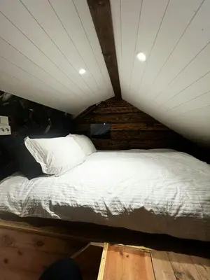 a large bed in a room with a ceiling at Restored Farmhouse By The Sea In Kvalheim in Raudeberg