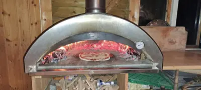 a pizza cooking in a wood fired oven at Restored Farmhouse By The Sea In Kvalheim in Raudeberg