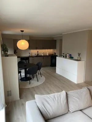 a living room and kitchen with a couch and a table at Great and modern apartment at Grilstad Marina! in Trondheim