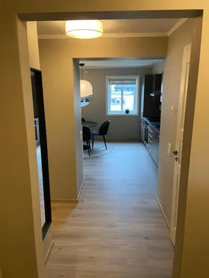 a hallway with a dining room and a dining table at Great and modern apartment at Grilstad Marina! in Trondheim