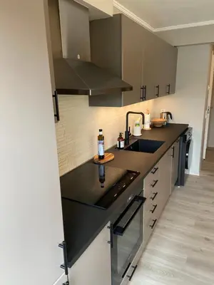 a kitchen with a black counter top and a sink at Great and modern apartment at Grilstad Marina! in Trondheim