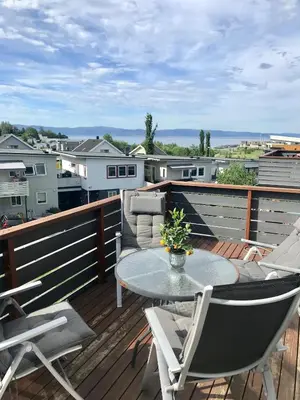 a patio with a table and chairs on a deck at Great and modern apartment at Grilstad Marina! in Trondheim
