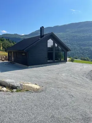 a house on a hill with a large driveway at Flott hytte i Sogndal skisenter-Hodlekve in Sogndal