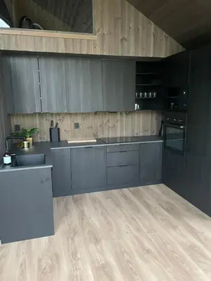 a kitchen with gray cabinets and a wooden floor at Flott hytte i Sogndal skisenter-Hodlekve in Sogndal