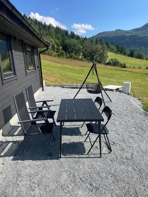 a picnic table and two chairs in front of a house at Flott hytte i Sogndal skisenter-Hodlekve in Sogndal