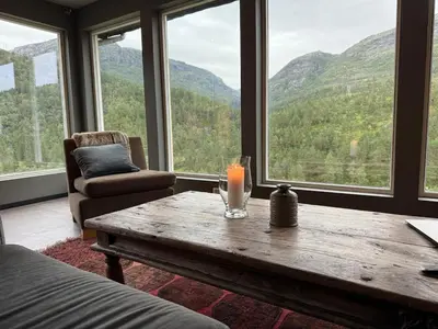 a room with a table with a candle and a chair at Fossen Bratte Mountain home in Eikedalen