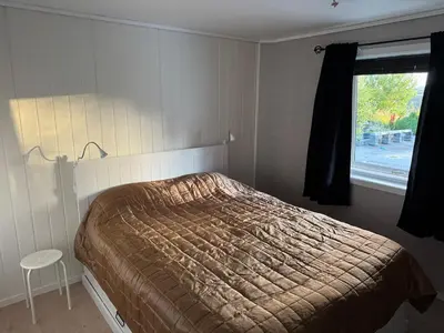 a bedroom with a bed and a window at Bergtun's Corner - Sotra Vest in Sekkingstad