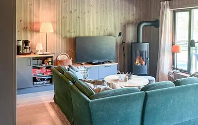 a living room with a blue couch and a tv at 3 Bedroom Awesome Apartment In Hemsedal in Hemsedal