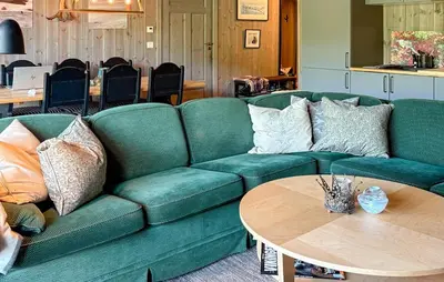 a living room with a green couch and a table at 3 Bedroom Awesome Apartment In Hemsedal in Hemsedal